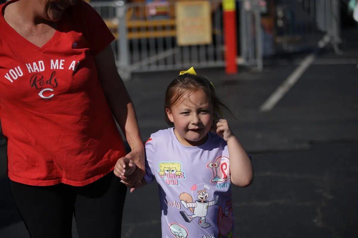 Krymsyn walking beside a family member on a sunny day